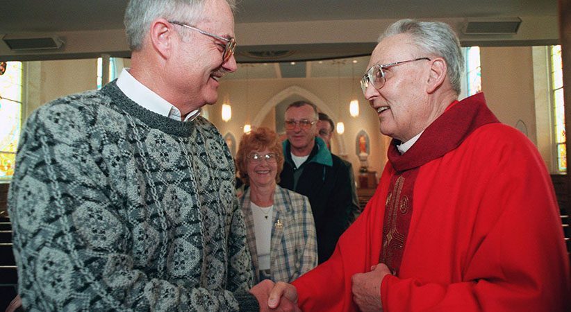 PRIEST GREETS PARISHIONERS FOLLOWING MASS