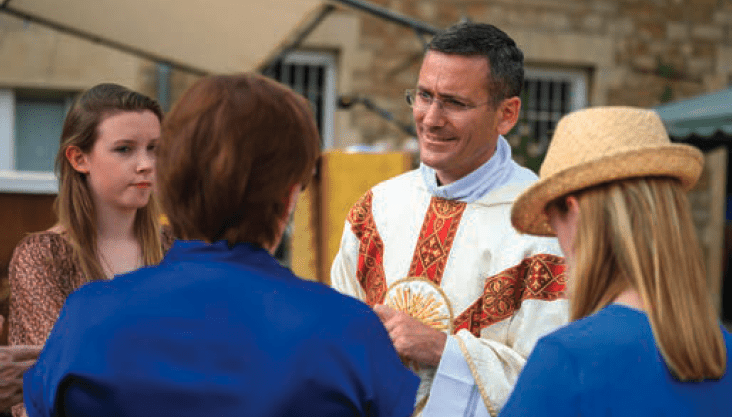priest greeting faithful